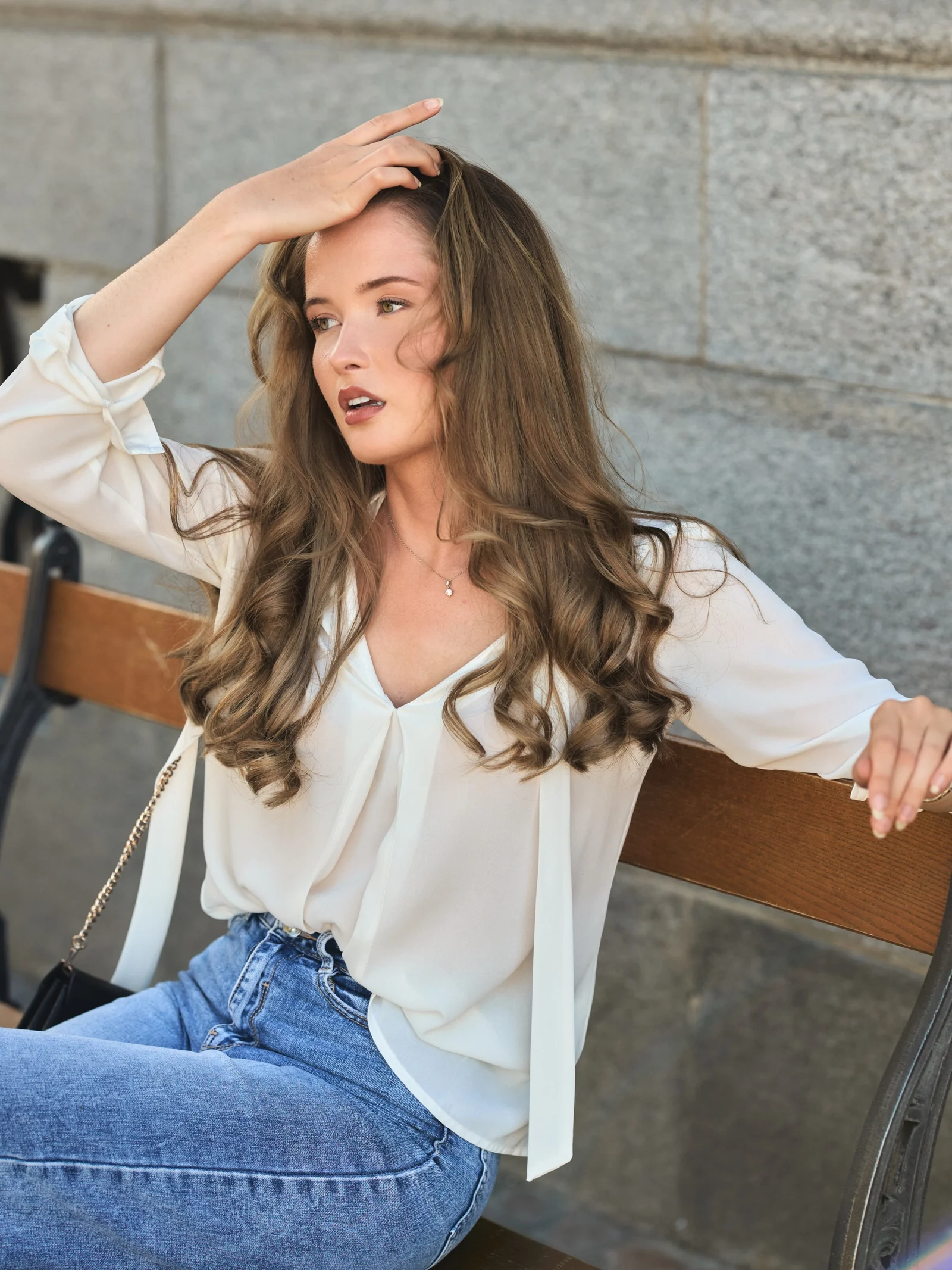 Eloïse, modèle, portrait assis sur un banc, main dans les cheveux, Bâle